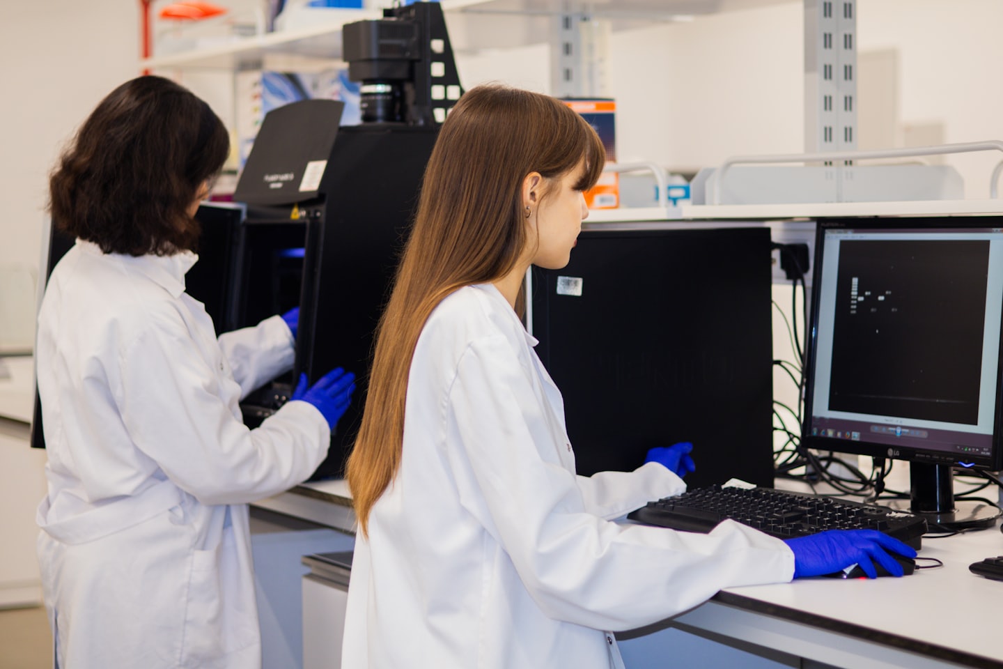 Naukowcy współpracują w nowoczesnym laboratorium, używając sprzętu naukowego i komputerów.